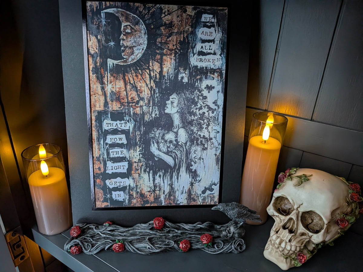We Are All Broken gothic canvas print displayed with candles and skull decor